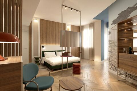 Modern hotel room with bed, wooden panels, blue chair, hanging TV, and champagne setup at B&B Hotel Milano Duomo Velasca