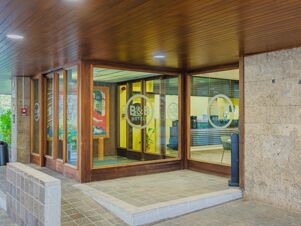 Glass entrance doors with wooden frames and B&B Hotels logos at the lobby entrance of B&B Hotel Fabriano Janus
