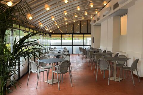 Indoor seating area with gray tables and chairs under a curved ceiling with multiple round lights at B&B Hotel Pesaro Des Bains
