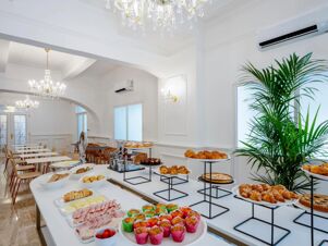 Buffet table with muffins, croissants, cold cuts, cheeses, bread, pastries, and a dining area at B&B Hotel Pesaro Des Bains