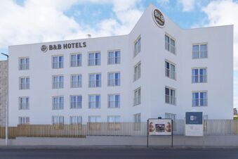 White modern building with multiple rectangular windows and balconies labeled B&B Hotels, B&B Hotel Sassari visible