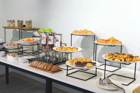 Breakfast buffet with assorted pastries, bread, muffins, fresh fruit, cereal jars, and condiments at B&B Hotel Catania City Center
