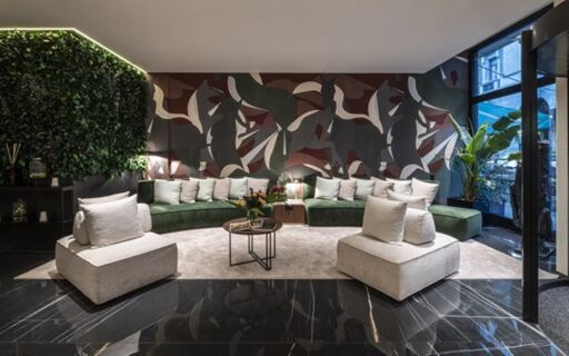 Modern hotel lobby at Duomo - Hotel Apartments Milano with green velvet sofas, beige chairs, abstract wall art, and plants