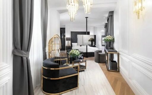 A modern hotel suite at The Plein Hotel - Small Luxury Hotels of the World with black and gold chairs and white marble flooring