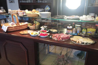 Breakfast buffet at Pension Haus Wiehenperle with sliced meats, cheeses, bread, fruit, Nutella, and various spreads on a wooden counter