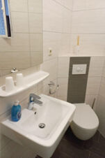 &Scaron;viesus ir tvarkingai įrengtas kompakti&scaron;kas, modernus vonios kambarys su praustuvu, tualetu ir vonios reikmenimis "Pension Zur Elbe" vie&scaron;butyje.