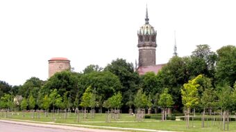 Vaizdas į parką su medžiais ir istoriniais bok&scaron;tais fone, idealiai tinkantį pasivaik&scaron;čiojimams &scaron;alia pensiono "Zur Elbe".