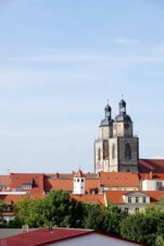 Istorinių pastatų ir bažnyčios bok&scaron;tų dvynių vaizdas giedru dangumi i&scaron; pensiono "Zur Elbe".