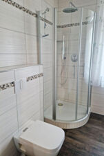 Modernus plytelėmis i&scaron;klotas vonios kambarys su du&scaron;u ir tualetu pensione "Zur Elbe", &scaron;viesus kambarys su natūralios &scaron;viesos &scaron;altiniais ir stilingais baldais.