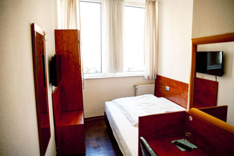 Kompaktes, helle Einzelzimmer mit Holzmoebeln und Fernseher im Hotel Haus Rheinblick, ideal fuer einen kurzen Aufenthalt.