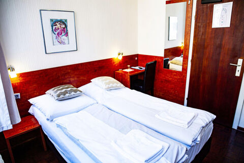Gem&uuml;tliches Doppelzimmer mit zwei Einzelbetten, Schreibtisch und Holzakzenten im Hotel Haus Rheinblick f&uuml;r entspannte &Uuml;bernachtungen.