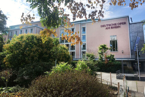 Au&szlig;enansicht mit viel Gr&uuml;n einer Oper in sonniger Umgebung, ideal f&uuml;r G&auml;ste des Hotel Haus Rheinblick nahe dem Rhein.