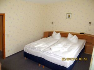 A twin bed setup with white pillows and folded towels in a hotel room at Parkhotel Luckau-Cahnsdorf