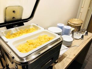 Buffet-Service mit warmem R&uuml;hrei und Geschirr im Fr&uuml;hst&uuml;cksbereich des Hotel-Restaurant Felmis Nichtraucherhaus.