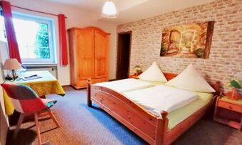 Gem&uuml;tliches Hotelzimmer mit Doppelbett, Holzm&ouml;beln und Fenster in Hotel Pension Haus Hahnenbecke, passend f&uuml;r erholsame N&auml;chte.