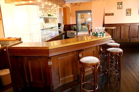 Die klassische Bar mit Holztheke und hohen Hockern im Hotel-G&auml;stehaus Br&uuml;ggemann l&auml;dt zum Verweilen in gem&uuml;tlicher Atmosph&auml;re ein.