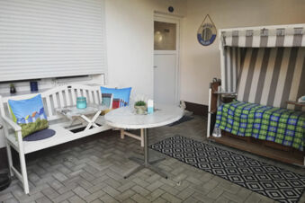 Gem&uuml;tliche Terrasse mit Strandkorb, Bank und Tisch im Landhotel Alte M&uuml;hle, ideal zum Entspannen im Freien.